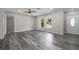 Bright living room featuring modern ceiling fan and wood-look flooring, leading to the front door at 732 Haleybury St, Port Charlotte, FL 33948
