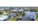 Aerial view of the waterfront property with boat lift, fenced yard, mature landscaping, and pool at 8178 Arlewood Cir, Port Charlotte, FL 33981