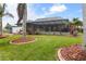 Beautifully landscaped backyard featuring a screened-in pool and a well-maintained lawn at 8178 Arlewood Cir, Port Charlotte, FL 33981