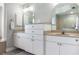 This bathroom features dual sinks with stone countertops, white cabinets, and neutral walls and floors at 8178 Arlewood Cir, Port Charlotte, FL 33981