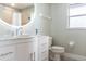 Modern bathroom vanity with white cabinets, stone countertop, round mirror, and neutral walls and floors at 8178 Arlewood Cir, Port Charlotte, FL 33981