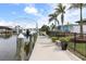 Wide boat dock featuring a boat lift with an array of tropical landscaping at 8178 Arlewood Cir, Port Charlotte, FL 33981