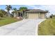 Elegant home featuring a spacious driveway with decorative concrete work and a manicured lawn at 8178 Arlewood Cir, Port Charlotte, FL 33981