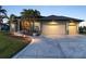 Beautifully landscaped home featuring a spacious three-car garage and a patterned concrete driveway at 8178 Arlewood Cir, Port Charlotte, FL 33981