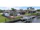 Exterior view with backyard boat lift on canal, fenced yard, and tropical landscaping in a relaxing setting at 8178 Arlewood Cir, Port Charlotte, FL 33981