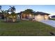 Beautiful home with manicured lawn, palm trees and patterned concrete driveway at 8178 Arlewood Cir, Port Charlotte, FL 33981