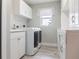 Well-organized laundry room with white cabinets, ample counter space, and modern washer and dryer at 8178 Arlewood Cir, Port Charlotte, FL 33981