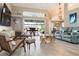 Spacious living room with modern furnishings, a unique driftwood coffee table, and access to the outdoor pool area at 8178 Arlewood Cir, Port Charlotte, FL 33981