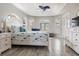 Bright main bedroom with wood flooring, tray ceiling, and large windows with white trim and plantation shutters at 8178 Arlewood Cir, Port Charlotte, FL 33981