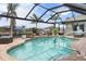 Inviting screened-in pool area with lush landscaping and tranquil water views, perfect for relaxation and entertaining at 8178 Arlewood Cir, Port Charlotte, FL 33981