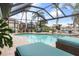 Relaxing screened-in pool area with lounge chairs and lush tropical landscaping provides ultimate privacy at 8178 Arlewood Cir, Port Charlotte, FL 33981