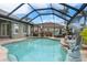 Sparkling screened-in pool with lovely dolphin statue and beautiful landscaping offers a tranquil oasis at 8178 Arlewood Cir, Port Charlotte, FL 33981