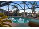 Relaxing screened-in pool area with tropical landscaping and comfortable outdoor seating at 8178 Arlewood Cir, Port Charlotte, FL 33981