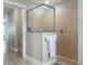 Modern shower with tile, frosted glass, and neutral colors, plus a view of the Primary suite at 8178 Arlewood Cir, Port Charlotte, FL 33981