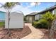 Charming yard featuring a storage shed, tropical plants, and a paver pathway leading to the home at 8178 Arlewood Cir, Port Charlotte, FL 33981