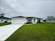 Charming single-story home featuring a well-manicured lawn, a two-car garage, and colorful landscaping at 8917 Sawyer Cir, North Port, FL 34288