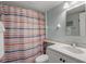 A bathroom is furnished with a toilet and a sink with striped shower curtain at 915 Beach Rd # 215, Siesta Key, FL 34242