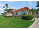 Beautiful Los Gatos Condominium building with terra cotta tile roof, mature landscaping, and manicured lawn on a sunny day at 915 Beach Rd # 215, Siesta Key, FL 34242