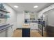 Well-lit kitchen featuring stainless steel appliances, butcher block island, and tile backsplash at 915 Beach Rd # 215, Siesta Key, FL 34242