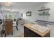 Open layout showing the kitchen with island, dining area, and living space with access to the balcony at 915 Beach Rd # 215, Siesta Key, FL 34242