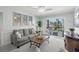 Comfortable living room with a gray sofa, beach themed art, balcony access and a welcome sign at 915 Beach Rd # 215, Siesta Key, FL 34242