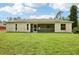 Rear exterior of home features a screened lanai and a spacious grassy backyard, perfect for outdoor enjoyment at 5260 Jessamine Ave, North Port, FL 34291