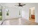 This bright bedroom features tile floors, a ceiling fan, and two windows, with the bathroom located through an archway at 5260 Jessamine Ave, North Port, FL 34291