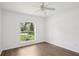 Well-lit bedroom boasts laminate floors, ceiling fan, and views of the outdoors through a charming arched window at 5260 Jessamine Ave, North Port, FL 34291