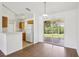 Bright dining area with wood floors, open to the kitchen and with a sliding glass door to the outside at 5260 Jessamine Ave, North Port, FL 34291