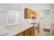 Kitchen showing wood cabinets, white appliances, and an open view to the front entryway at 5260 Jessamine Ave, North Port, FL 34291