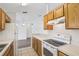 Functional kitchen featuring wood cabinets, white appliances, and an open layout to the living space at 5260 Jessamine Ave, North Port, FL 34291