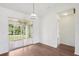 Living room view with wood floors, sliding glass doors to the screened patio, and neutral decor at 5260 Jessamine Ave, North Port, FL 34291