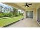 Covered patio area perfect for outdoor relaxation, featuring a ceiling fan and screened enclosure with a view of the backyard at 5260 Jessamine Ave, North Port, FL 34291
