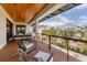 The covered balcony has comfortable seating with a light wood ceiling and view of the palm trees and surrounding area at 10009 Gasparilla Pass Blvd, Boca Grande, FL 33921