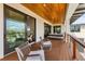 Balcony featuring comfortable chairs and a glimpse into the property’s interior through sliding glass doors at 10009 Gasparilla Pass Blvd, Boca Grande, FL 33921