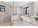 The spacious bathroom features a freestanding tub, tiled walls and floors, and a glass shower at 10009 Gasparilla Pass Blvd, Boca Grande, FL 33921