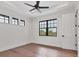 This airy bedroom has wood floors, large windows, and a ceiling fan at 10009 Gasparilla Pass Blvd, Boca Grande, FL 33921