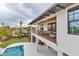 An elevated view of a modern home with a balcony, a pool, and lush landscaping that surround the property at 10009 Gasparilla Pass Blvd, Boca Grande, FL 33921