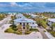 Aerial view of a coastal estate with a metal roof, lush landscaping, and proximity to the ocean at 10009 Gasparilla Pass Blvd, Boca Grande, FL 33921