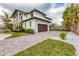 Exterior view of a modern two story home, with attached garage and stone paver driveway at 10009 Gasparilla Pass Blvd, Boca Grande, FL 33921