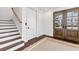 Foyer featuring hardwood floors, a staircase, and a stylish entry door, creating a welcoming entrance at 10009 Gasparilla Pass Blvd, Boca Grande, FL 33921