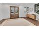 Bright and airy foyer with hardwood floors, statement rug, elegant entry doors and natural light at 10009 Gasparilla Pass Blvd, Boca Grande, FL 33921