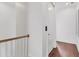 Bright upstairs hallway featuring hardwood floors, white walls, and modern door at 10009 Gasparilla Pass Blvd, Boca Grande, FL 33921