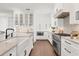Kitchen with white cabinets, stainless steel appliances, and dark hardwood floors at 10009 Gasparilla Pass Blvd, Boca Grande, FL 33921