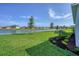 Landscaped backyard with lake view at 16824 Canopy Garden Dr, Port Charlotte, FL 33953