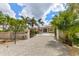 Elegant home exterior with gated entry and palm trees at 8035 Manasota Key Rd, Englewood, FL 34223
