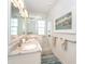Bathroom with double vanity, granite countertops, tiled walk-in shower, and decorative art at 261 N Gulf Blvd, Placida, FL 33946