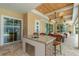Outdoor kitchen with granite island, seating, and built-in sink at 8074 Wiltshire Dr, Port Charlotte, FL 33981