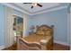 Light blue bedroom with gold bedding and sliding glass door to patio at 8074 Wiltshire Dr, Port Charlotte, FL 33981