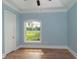Bright bedroom with hardwood floors and a large window offering a view of the backyard at 8074 Wiltshire Dr, Port Charlotte, FL 33981